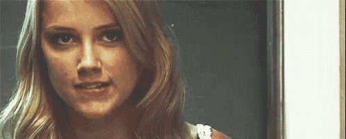 a close up of a woman 's face looking at the camera with a serious look on her face .