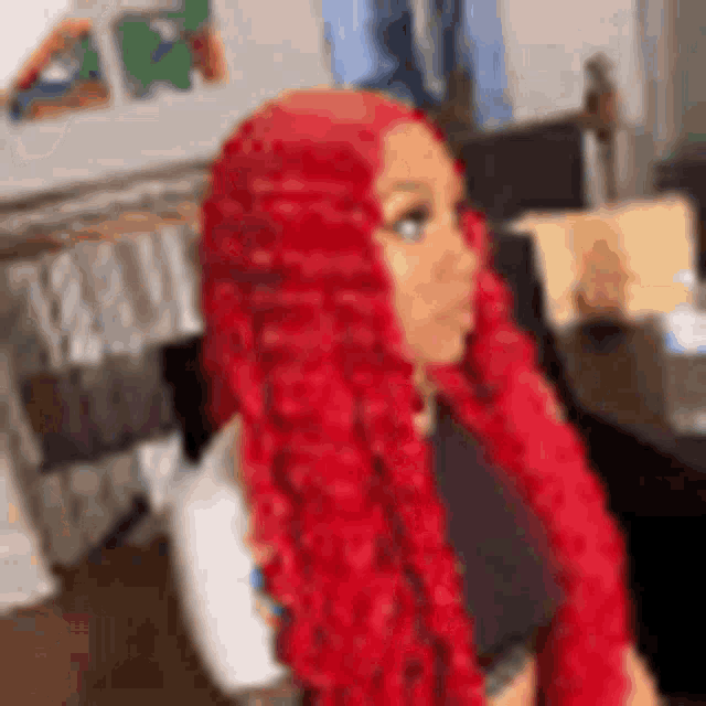 a woman with red curly hair is sitting in a chair .