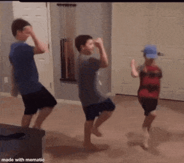 three boys are dancing in a living room .