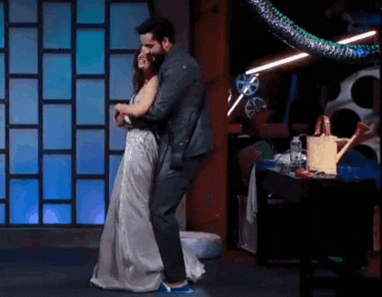a man and a woman are dancing on a stage in a room .