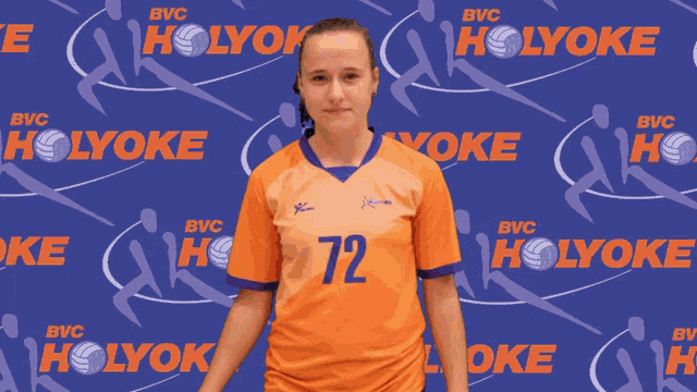 a girl wearing an orange jersey with the number 72