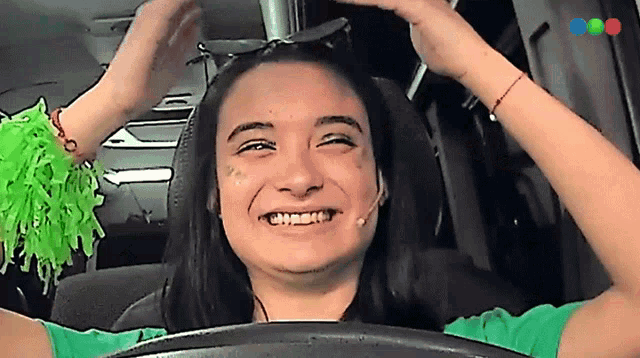 a woman wearing sunglasses and a green shirt is smiling