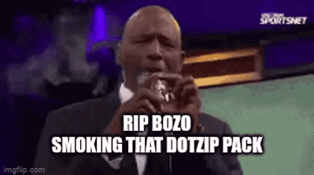 a man in a suit and tie is smoking a pack of cigarettes .