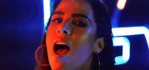 a close up of a woman 's face with her mouth open and her tongue sticking out .