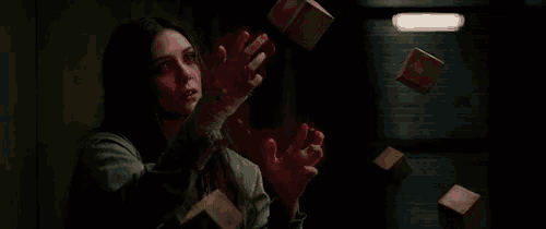 a woman is holding a box with a red light coming out of her hands