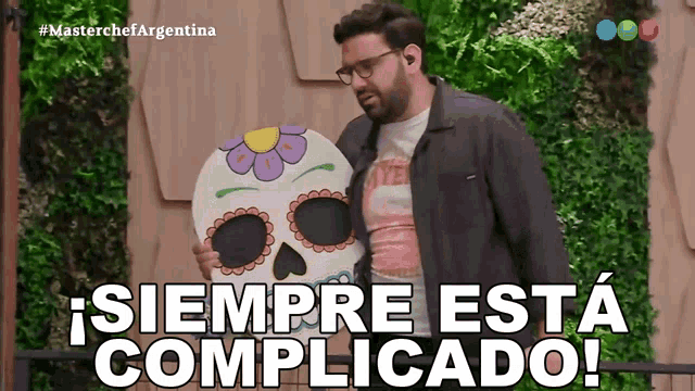 a man holding a skull that says " siempre esta complicado " on the bottom