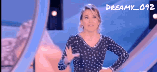 a woman in a polka dot dress is standing in front of a blue background with the words dreamy_092 written on it