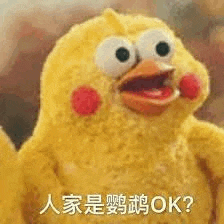 a stuffed chicken with big eyes and red cheeks is making a funny face with its mouth open .
