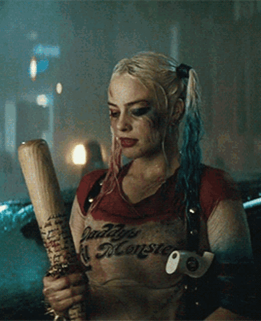 a woman in a harley quinn shirt is holding a baseball bat