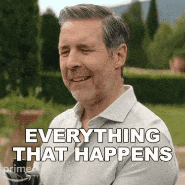 a man with a beard is smiling and says " everything that happens "