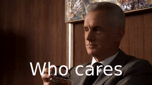 a man in a suit and tie is holding a glass of whiskey and the words who cares are behind him