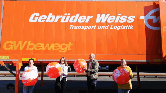 a group of people holding balloons in front of a truck that says gbruder weiss