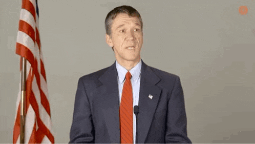 a man in a suit and tie is giving a speech