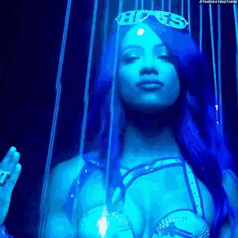 a woman with blue hair and a crown on her head is standing in a cage .