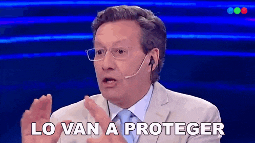 a man wearing glasses and a microphone says " lo van a proteger "