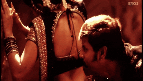 a man kissing a woman 's back with eros written on the bottom of the screen