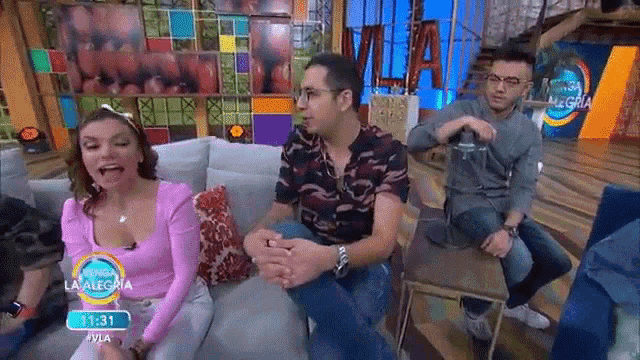 a group of people are sitting on a couch in front of a television .