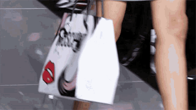 a woman is carrying a purse with a picture of a woman 's face on it