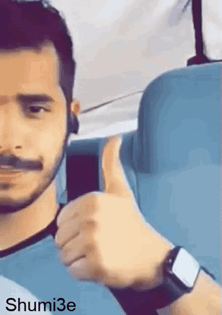 a man with a beard is giving a thumbs up sign