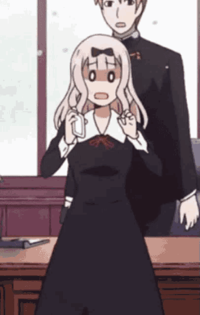 a girl in a black dress has a surprised look on her face while standing next to a man