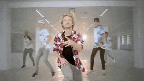 a group of young men are dancing together in a room .