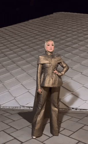 a woman wearing a hijab is standing in front of a roof