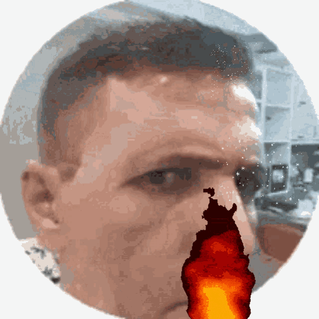 a close up of a man 's face with a red flame coming out of his nose