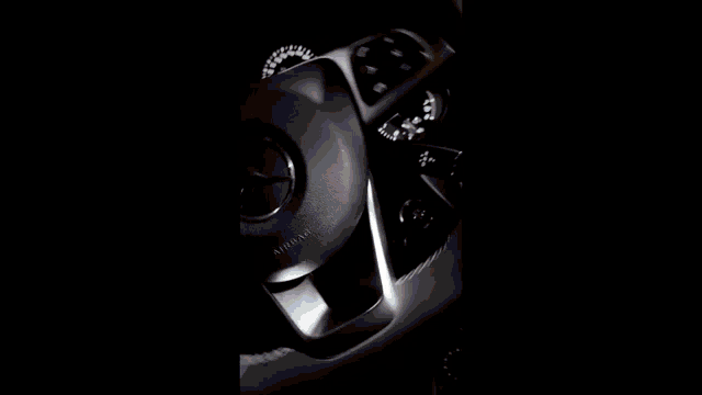a black suv is driving down a street at night