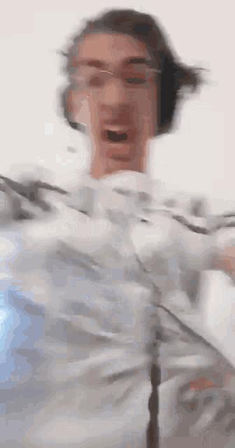 a blurry picture of a man wearing headphones and holding a remote control .