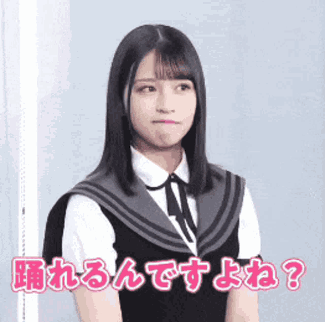 a girl in a school uniform is standing in front of a sign that says " 踊れる ん です よ ね "