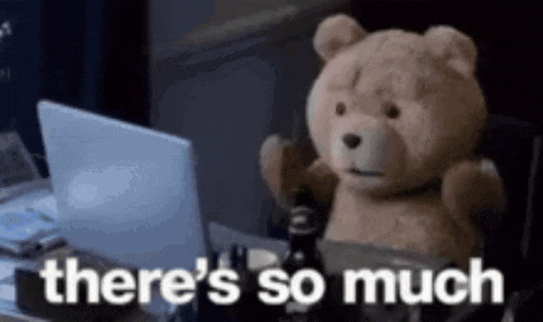 a teddy bear is sitting at a desk in front of a laptop .