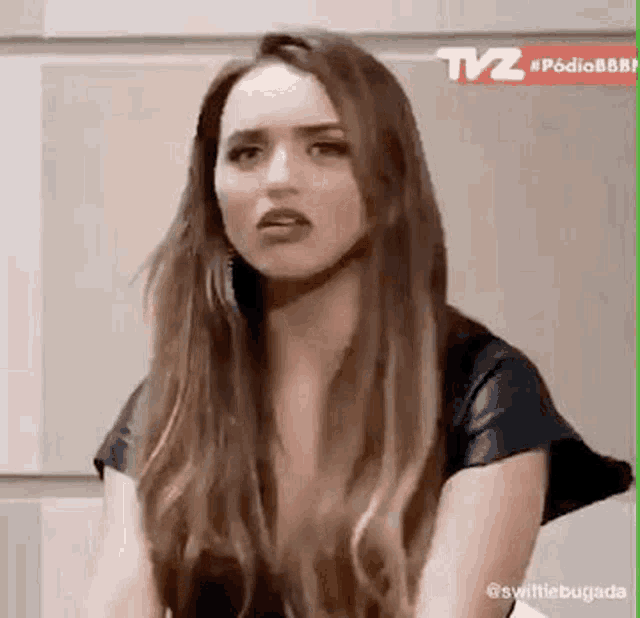 a woman with long hair is making a funny face while sitting on a chair .