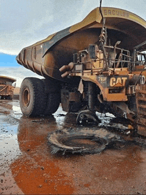 a cat dump truck is sitting in a muddy field