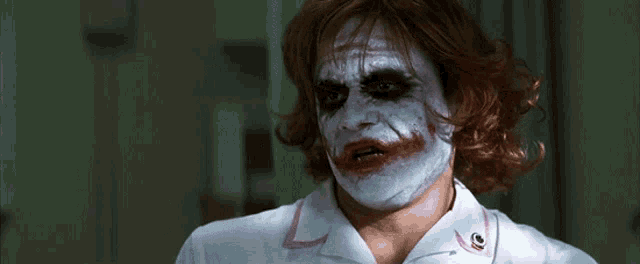 a man dressed as the joker is wearing a white nurse uniform