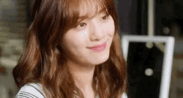 a close up of a woman 's face with long brown hair and bangs .