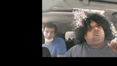 two men are sitting in the back seat of a car one is wearing a bandage around his neck