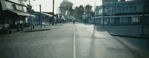 a person is running down a street in a small town .