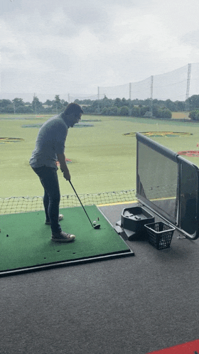 a man is swinging a golf club at a golf ball