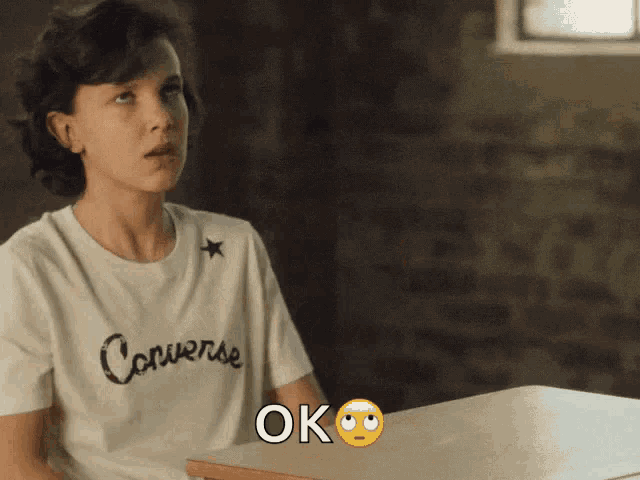 a girl wearing a converse t-shirt says ok