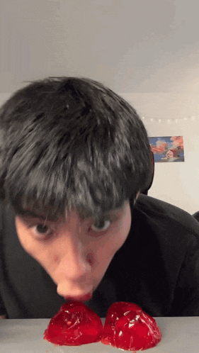 a young man is licking two pieces of jelly