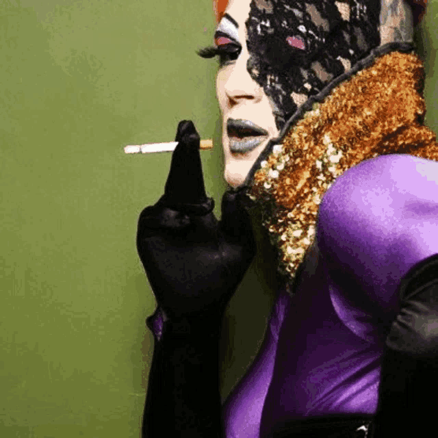 a woman in a purple outfit is smoking a cigarette and has a lace mask on her face