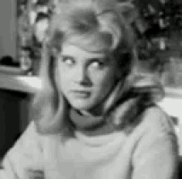 a black and white photo of a woman sitting at a table