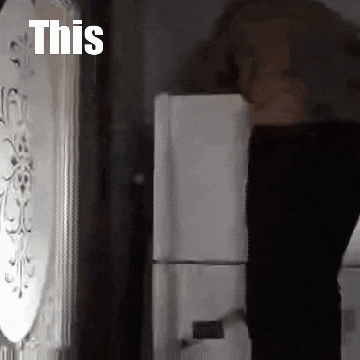 a person is standing in front of a refrigerator with the words `` this '' written on the wall .