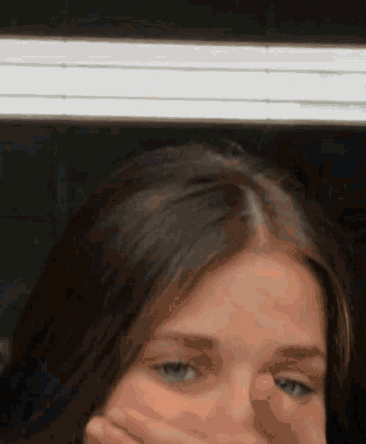 a close up of a woman 's face with a white light behind her