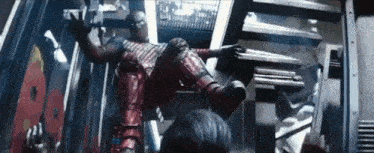 a man in a superhero costume is laying on his back on a set of stairs .