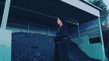 a person standing in front of a pile of rocks with a purple light coming out of it