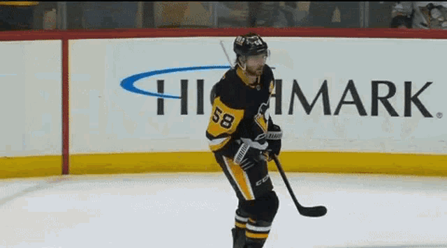 a hockey player with the number 58 on his jersey stands on the ice