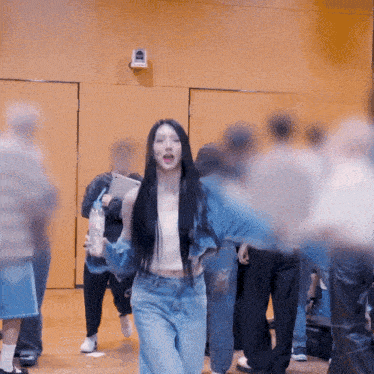 a woman with long black hair is standing in a crowd of people
