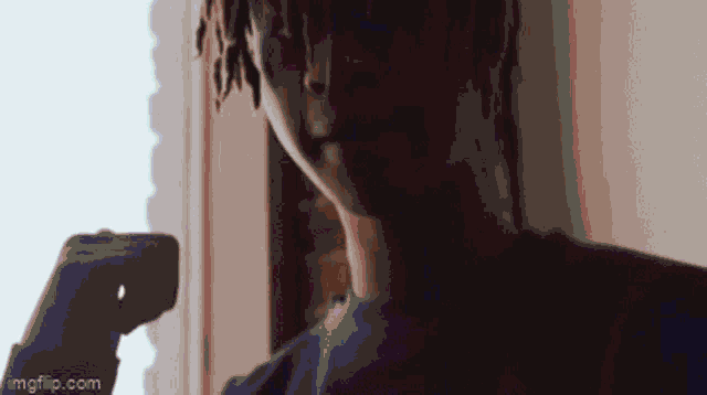 a close up of a person holding a cell phone in their hand .