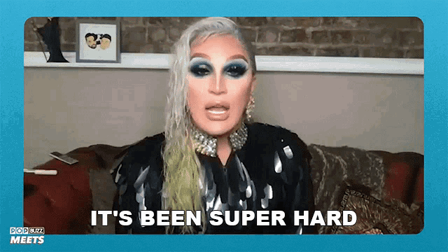 a drag queen is sitting on a couch saying it 's been super hard .
